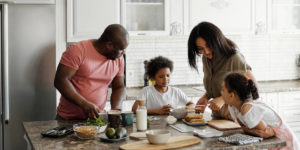 Gelukkige familie die een gezonde maaltijd in hun keuken voorbereidt