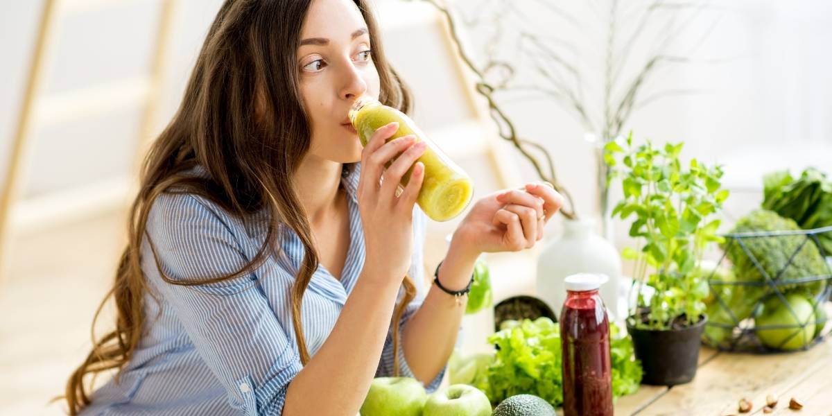 vrouw die groene smoothie drinkt